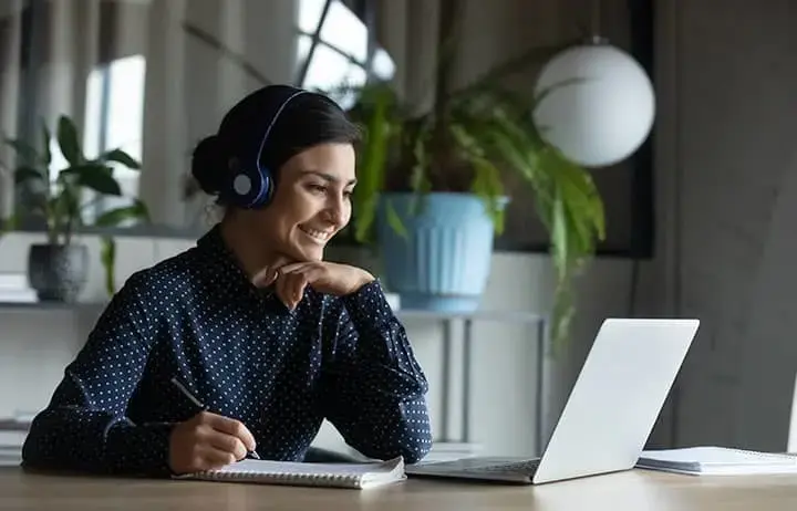 Smiling woman watching webinar on laptop